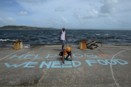 People writing on the floor hoping someone will help and rescue them. https://www.spiegel.de/fotostrecke/photo-gallery-in-the-wake-of-typhoon-haiyan-fotostrecke-103644-10.html